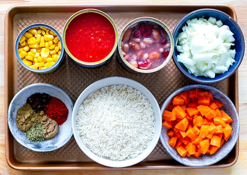 Ingredients in burrito bowl: rice, beans, corn, canned tomatoes, onions and carrots