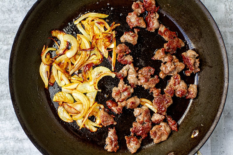 Fried sausage meat in a pan with onions