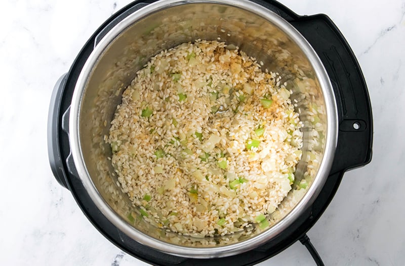 How to make Instant Pot shrimp risotto step 4 - add the rice, lemon zest and garlic