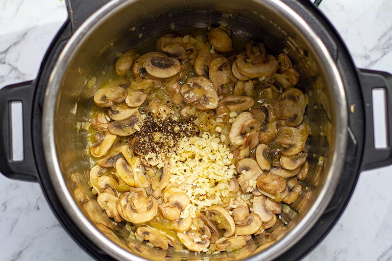 Add wine, garlic and pepper to the mushrooms in Instant pot