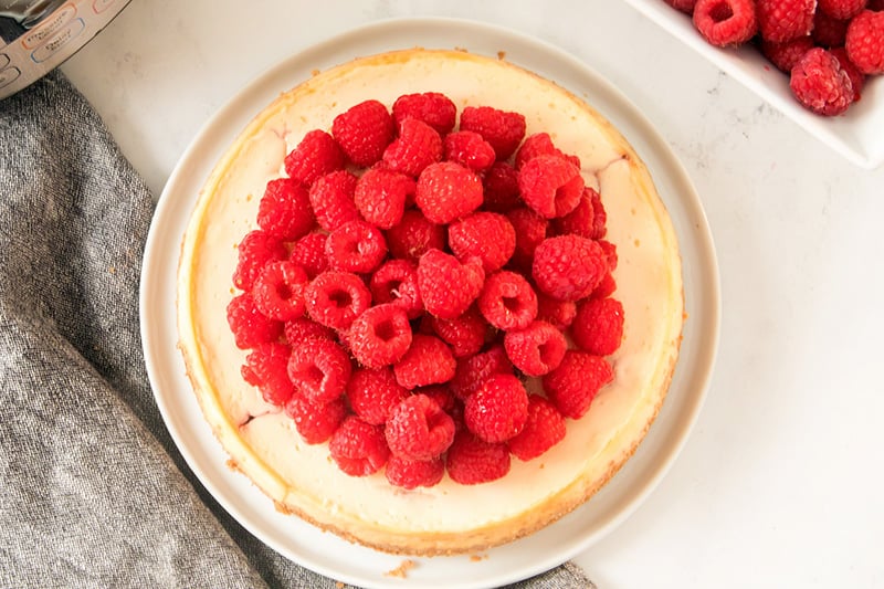 Raspberries on top of white chocolate cheesecake