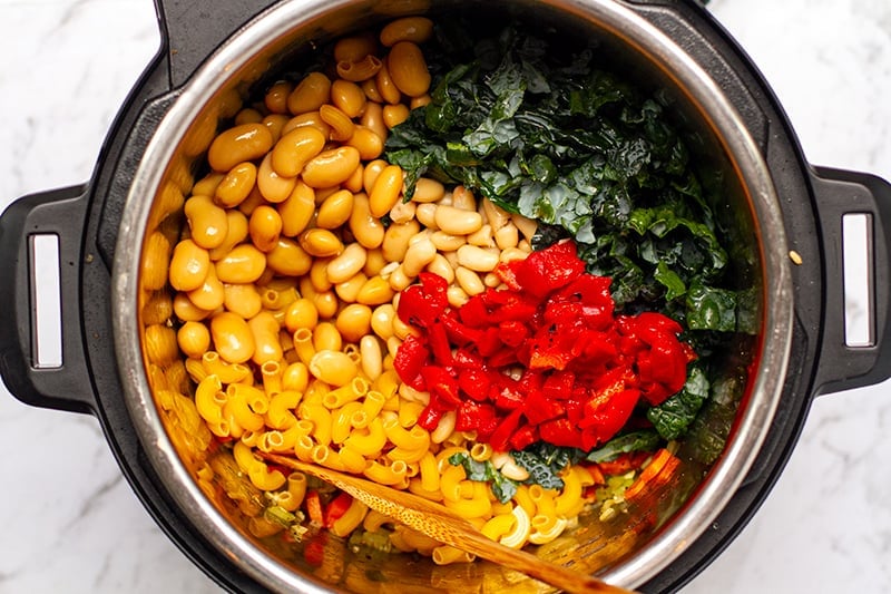Pasta and beans with cavolo nero (tuscan kale) and red peppers in the pot 