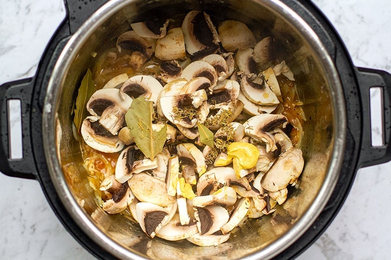 Add mushrooms and seasoning to the Instant Pot for chicken fricassee recipe