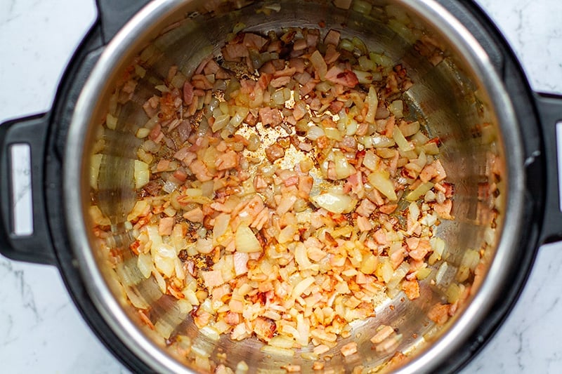 Saute onions and bacon for bean soup