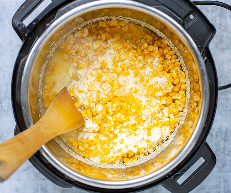 Stirring the cheese into creamed corn