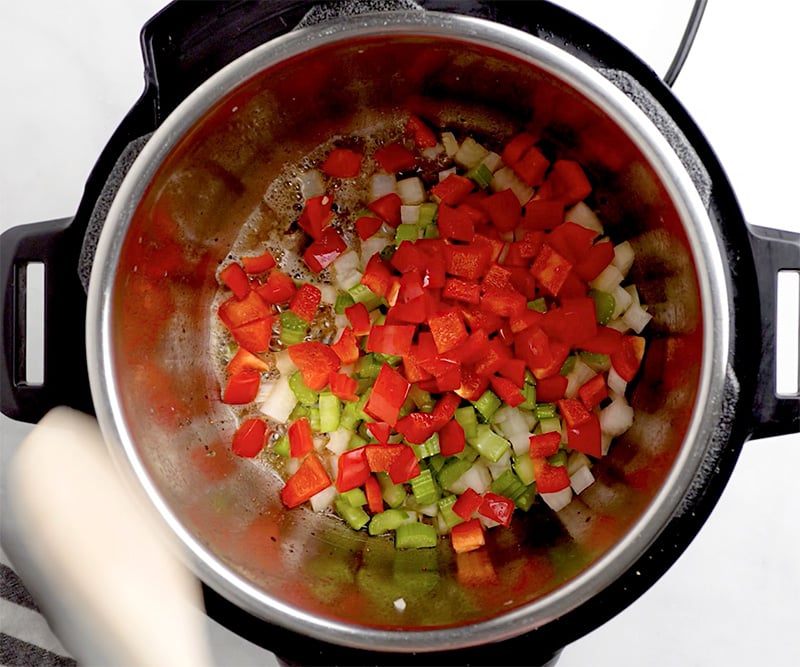 Add a tablespoon of butter, diced onions, celery and red peppers. 