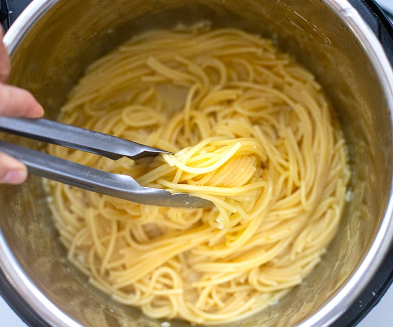 Stir the spaghetti for Spaghetti With Shrimp Scampi.