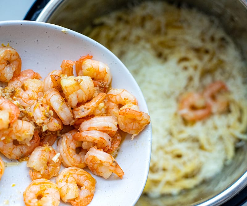 Return most of the pre-cooked shrimp and juices for Spaghetti With Shrimp Scampi.