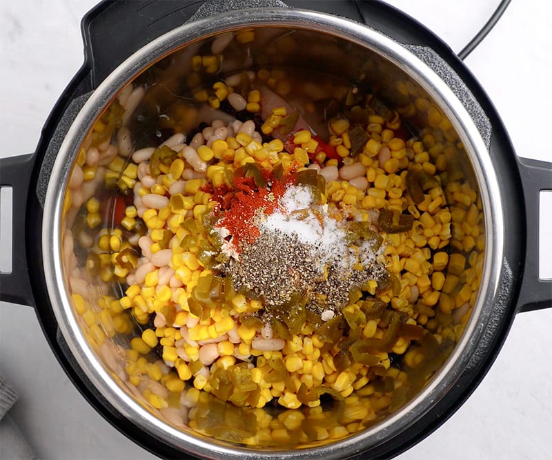 Add all ingredients to the Instant Pot except for canned tomatoes and stir through.