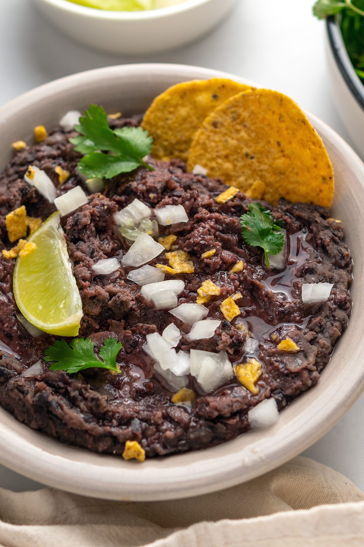 This Instant Pot Refried Beans recipe will teach you how to cook dry black beans and turn them into flavor-packed, creamy refried goodness using the Pressure Cooking and Saute functions. Serve as a dip or a side with your favorite toppings and corn tortilla chips.