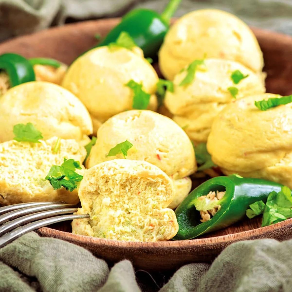 A plate of Instant Pot Cheesy Jalapeño Egg Bites, golden and fluffy, filled with melted cheese and diced jalapeños, served as a delicious, protein-packed snack.