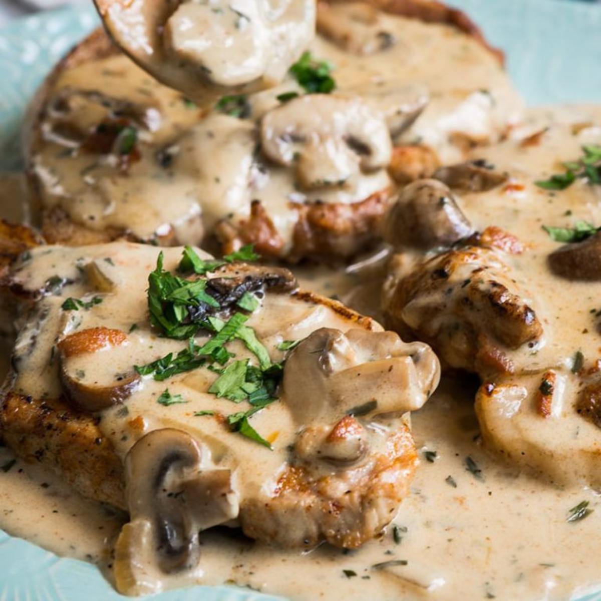 Tender Instant Pot Pork Chops cooked to perfection in a savory sauce, served with herbs.