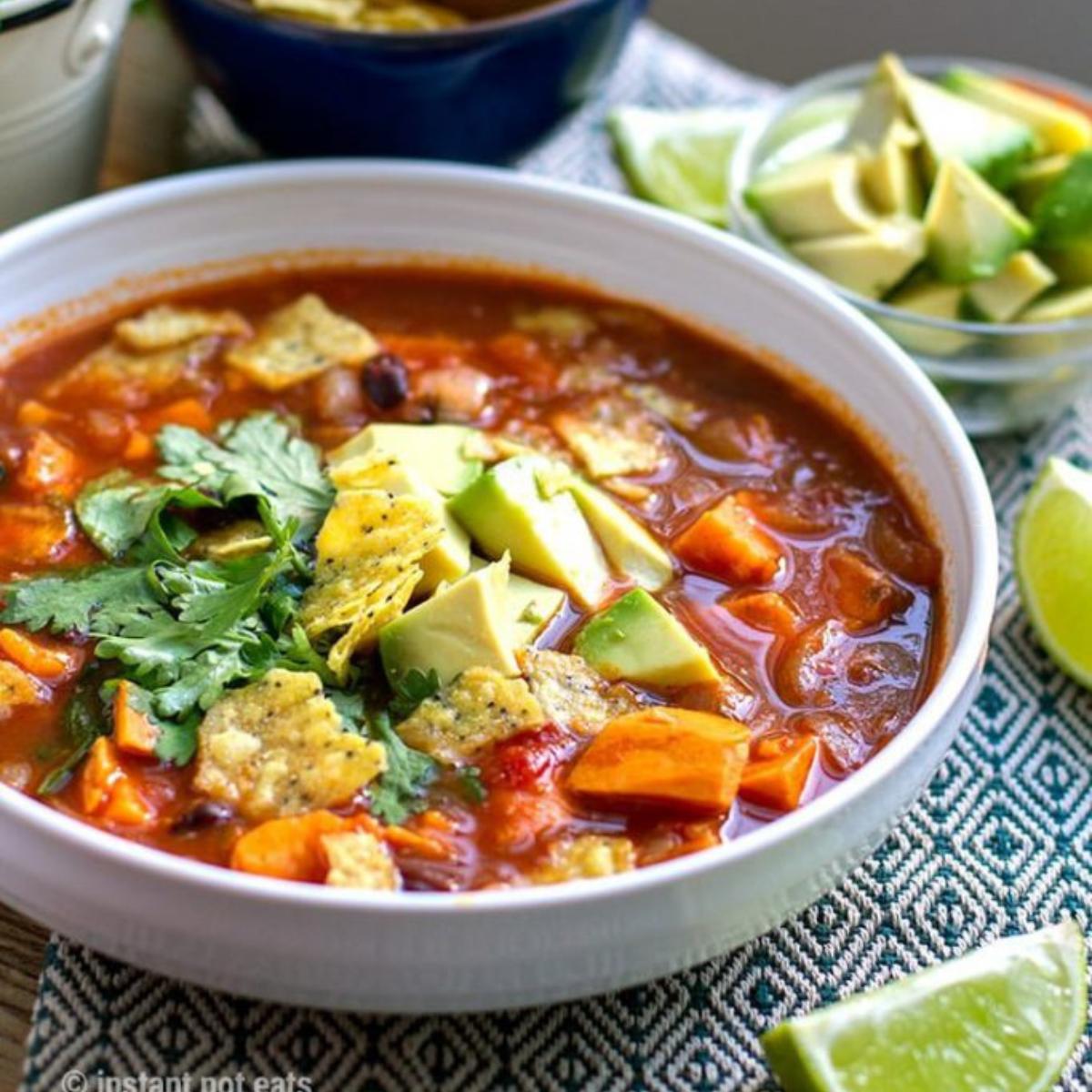 A flavorful Instant Pot Sweet Potato Tortilla Soup with tender sweet potatoes, black beans, tomatoes, and spices, topped with crispy tortilla strips and avocado.







