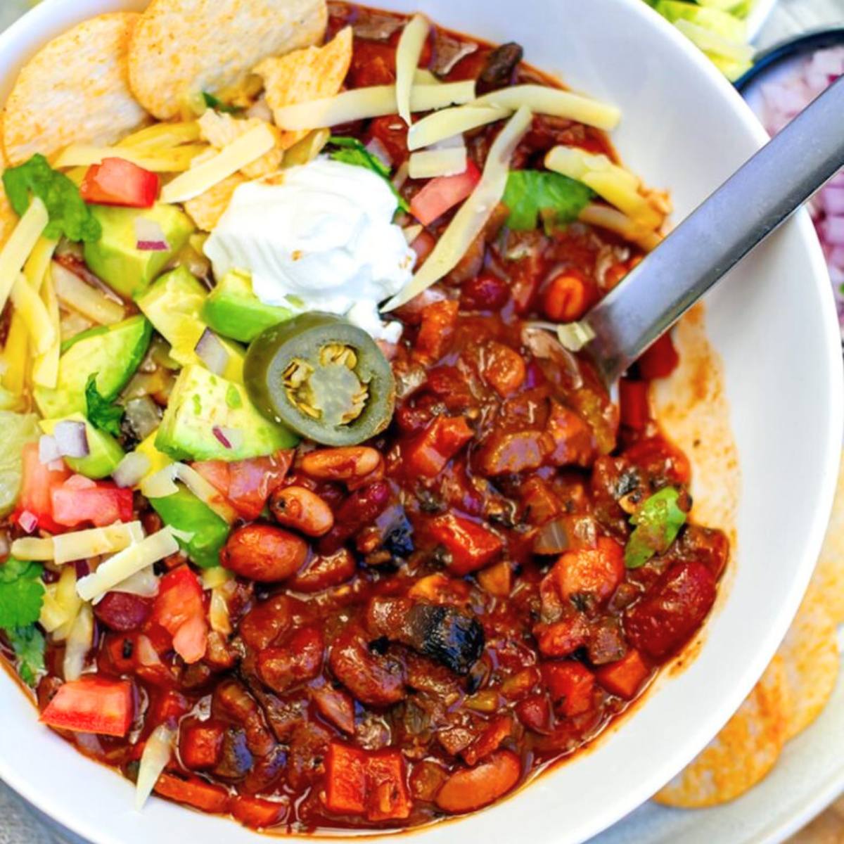 A hearty Vegetarian Mushroom Chili made with a variety of mushrooms, beans, and vegetables in a spiced tomato base, topped with fresh cilantro and avocado.







