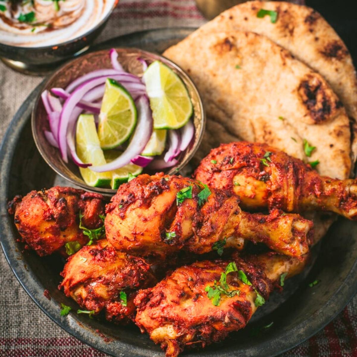 Juicy Instant Pot tandoori chicken with a vibrant spice crust, garnished with fresh cilantro and lemon wedges on the side.
