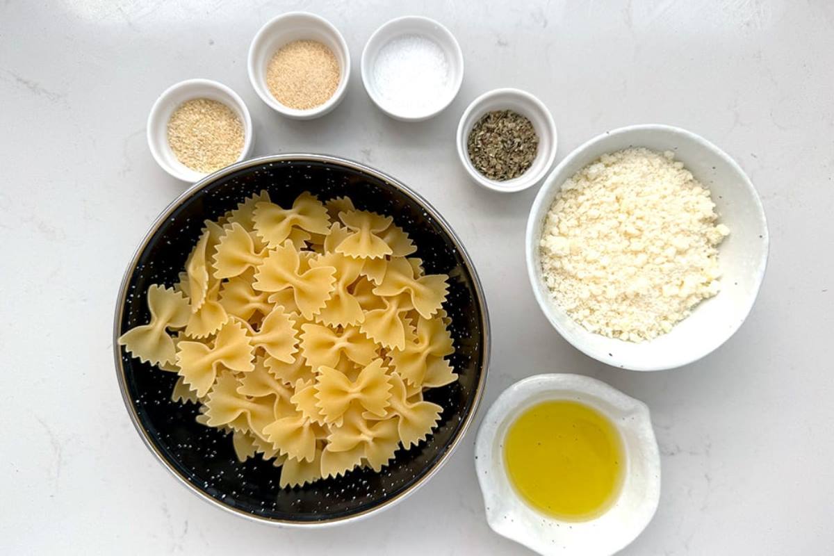 pasta chips ingredients in plates: pasta, olive oil, seasoning, parmesan cheese