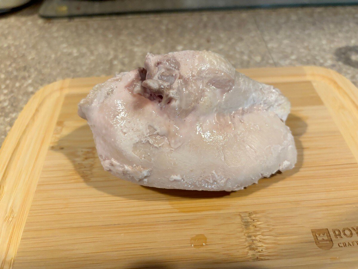 sous vide chicken breast on top of wooden chopping board