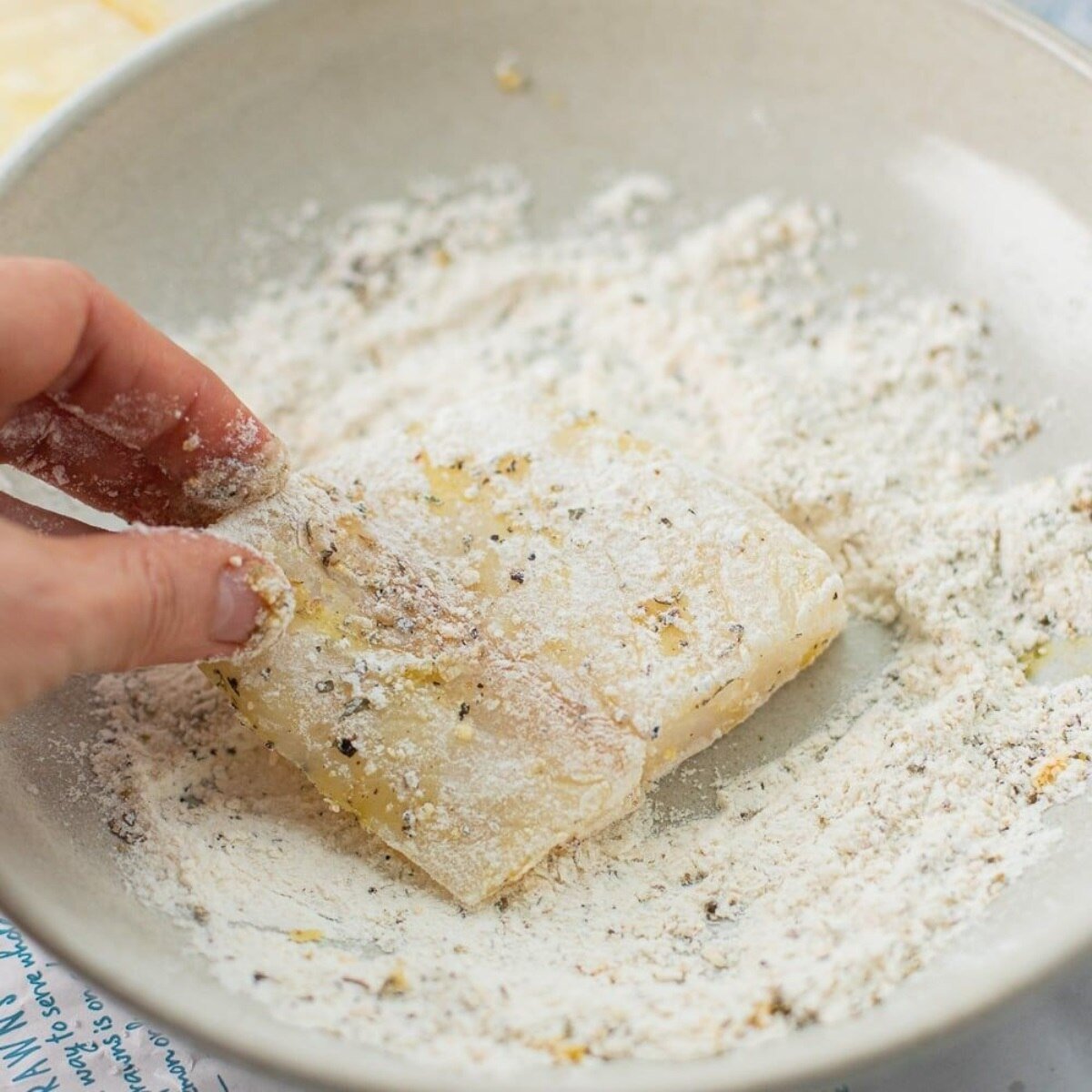 cod pieces are evenly coated with the seasoned flour