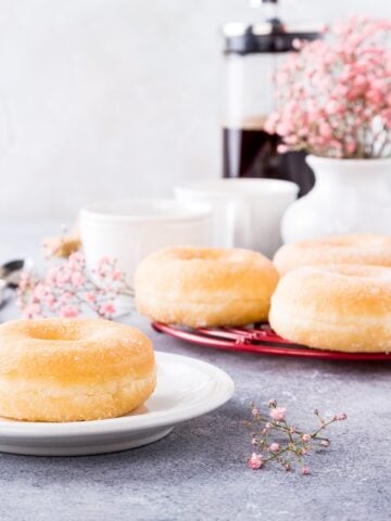 doughnuts with powdered sugar and cups of coffee