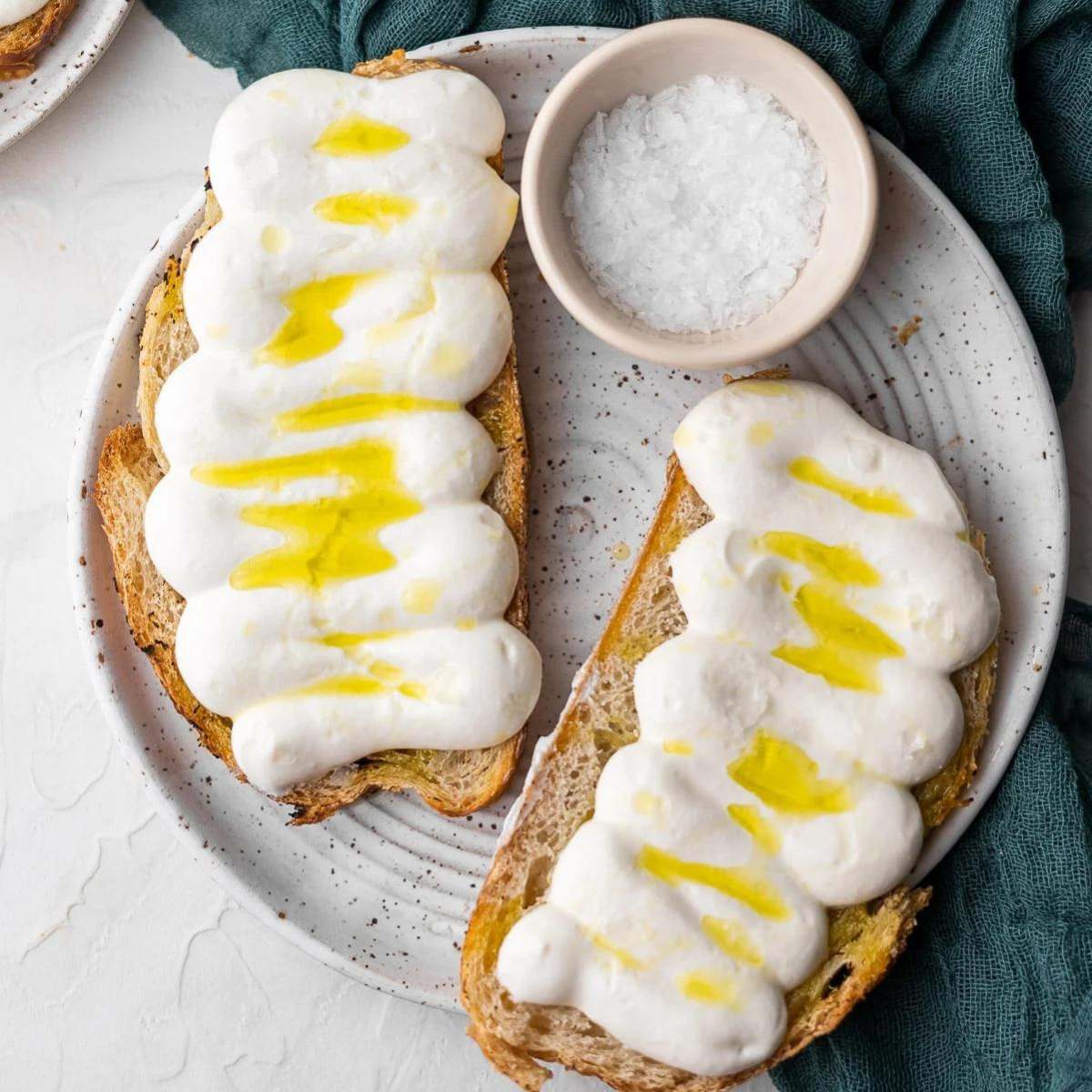  Two slices of toasted bread topped with whipped ricotta cheese and drizzled with olive oil. cold appetizer recipes