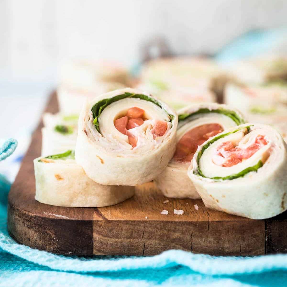 Turkey tortilla roll-ups on a wooden board. 