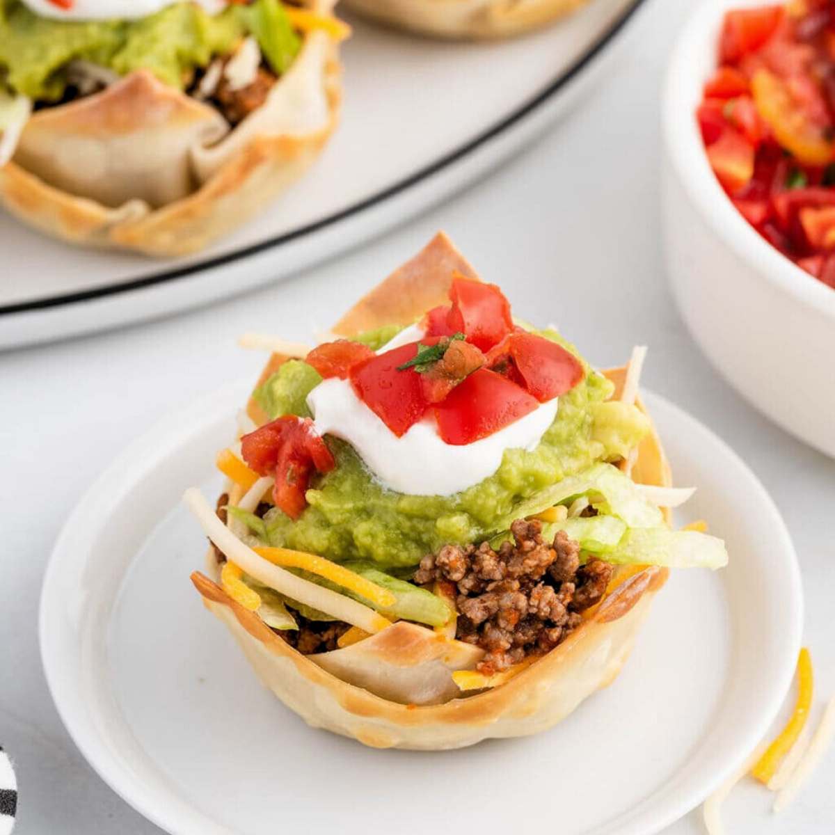  A crispy wonton wrapper filled with seasoned ground beef, shredded cheese, lettuce, tomato, sour cream, and guacamole.