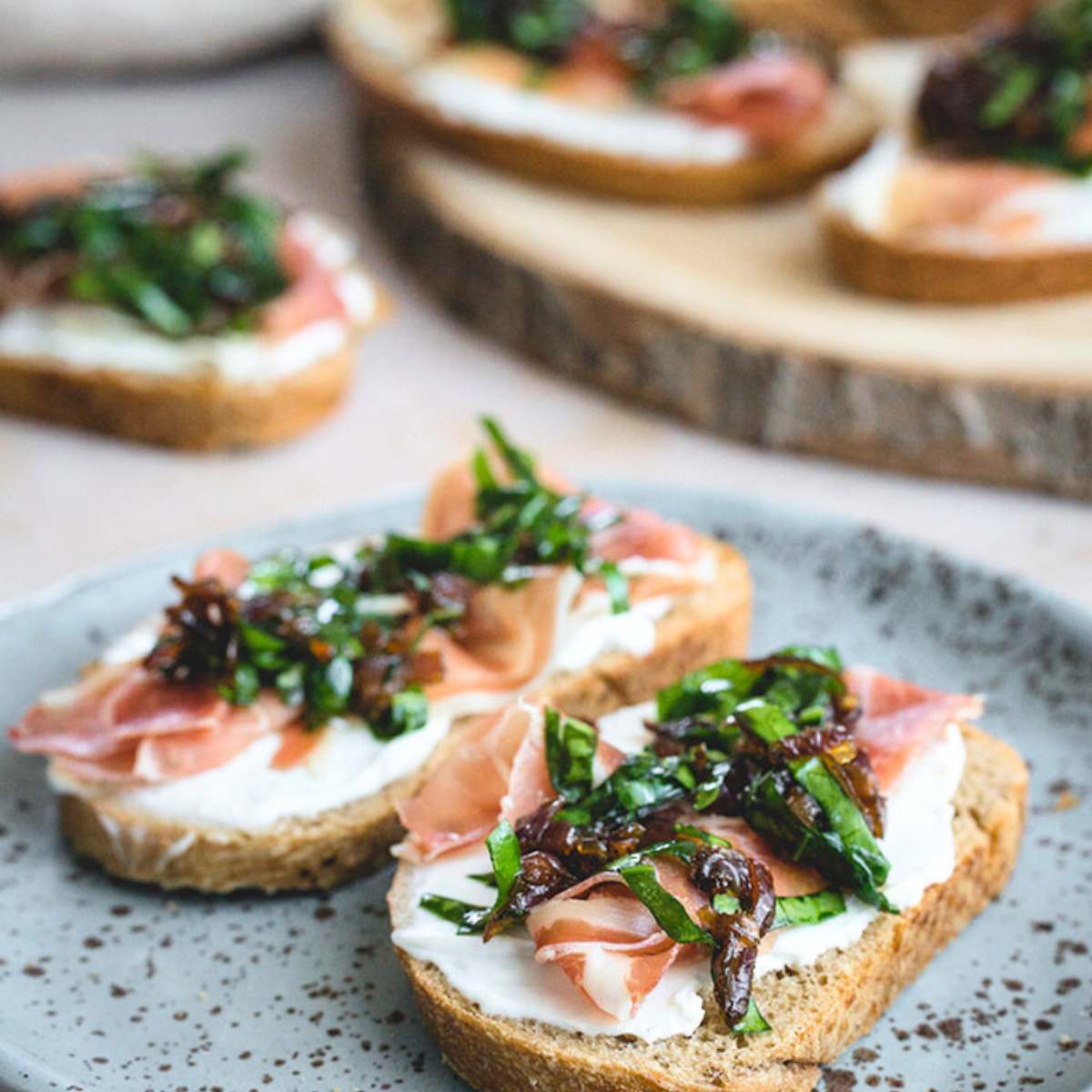 Crostini bread with goat cheese and caramelized onion on a plate. cold appetizer recipes