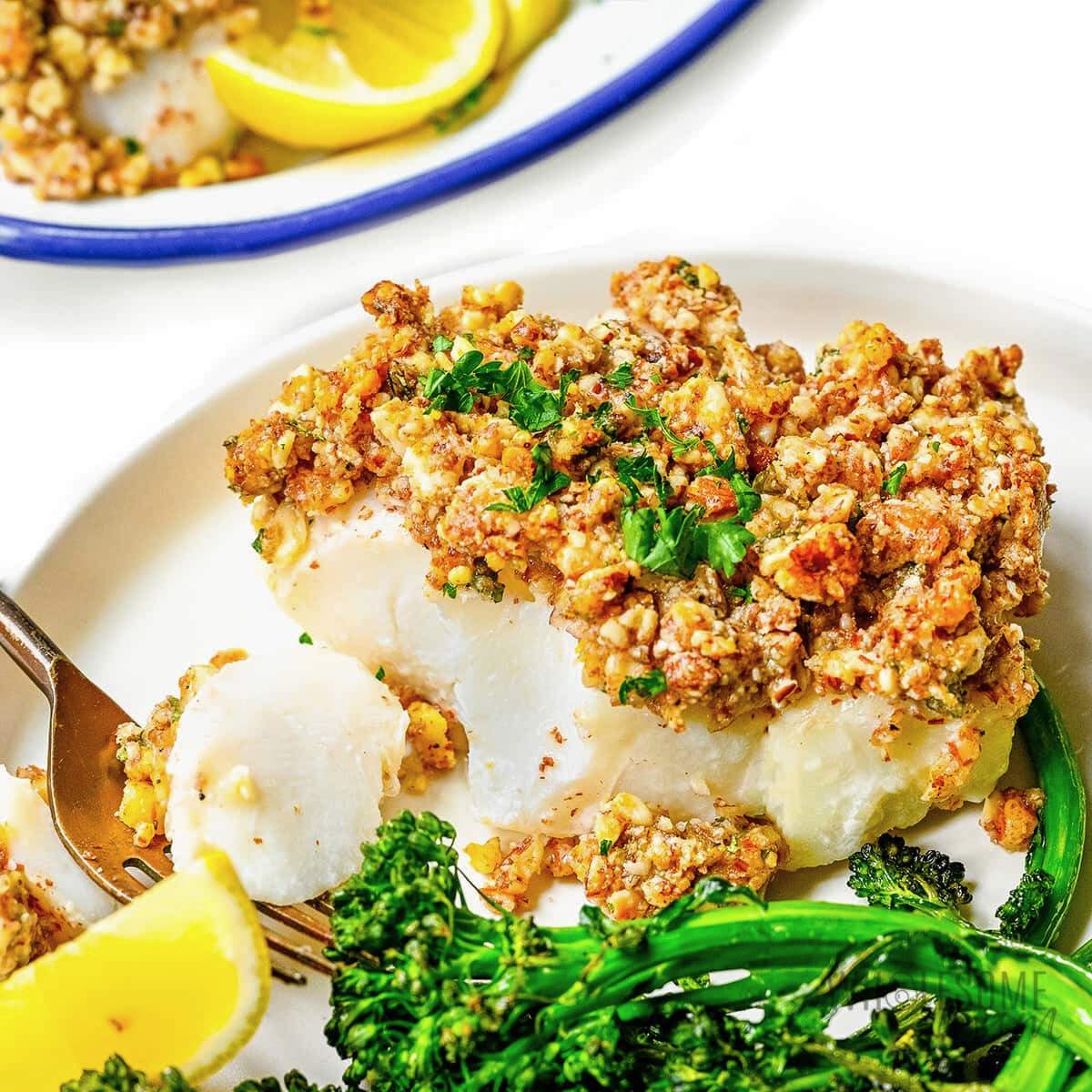 Baked white fish with a walnut and breadcrumb topping served with roasted broccoli.