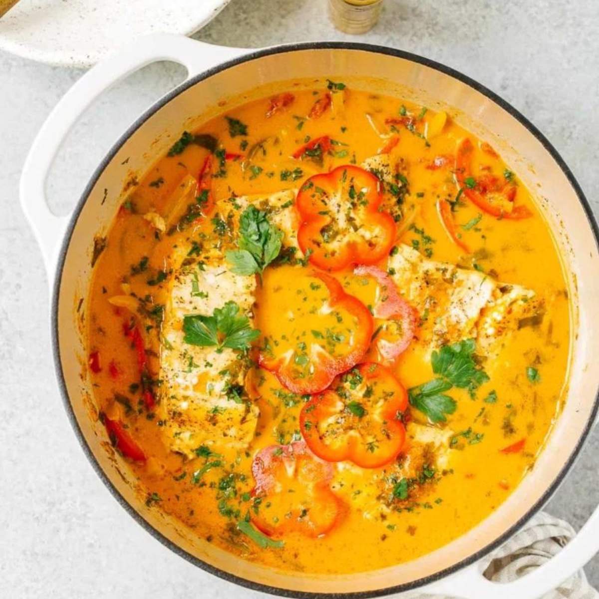 Fish orange stew with tomatoes, bell peppers, and a creamy coconut milk broth.