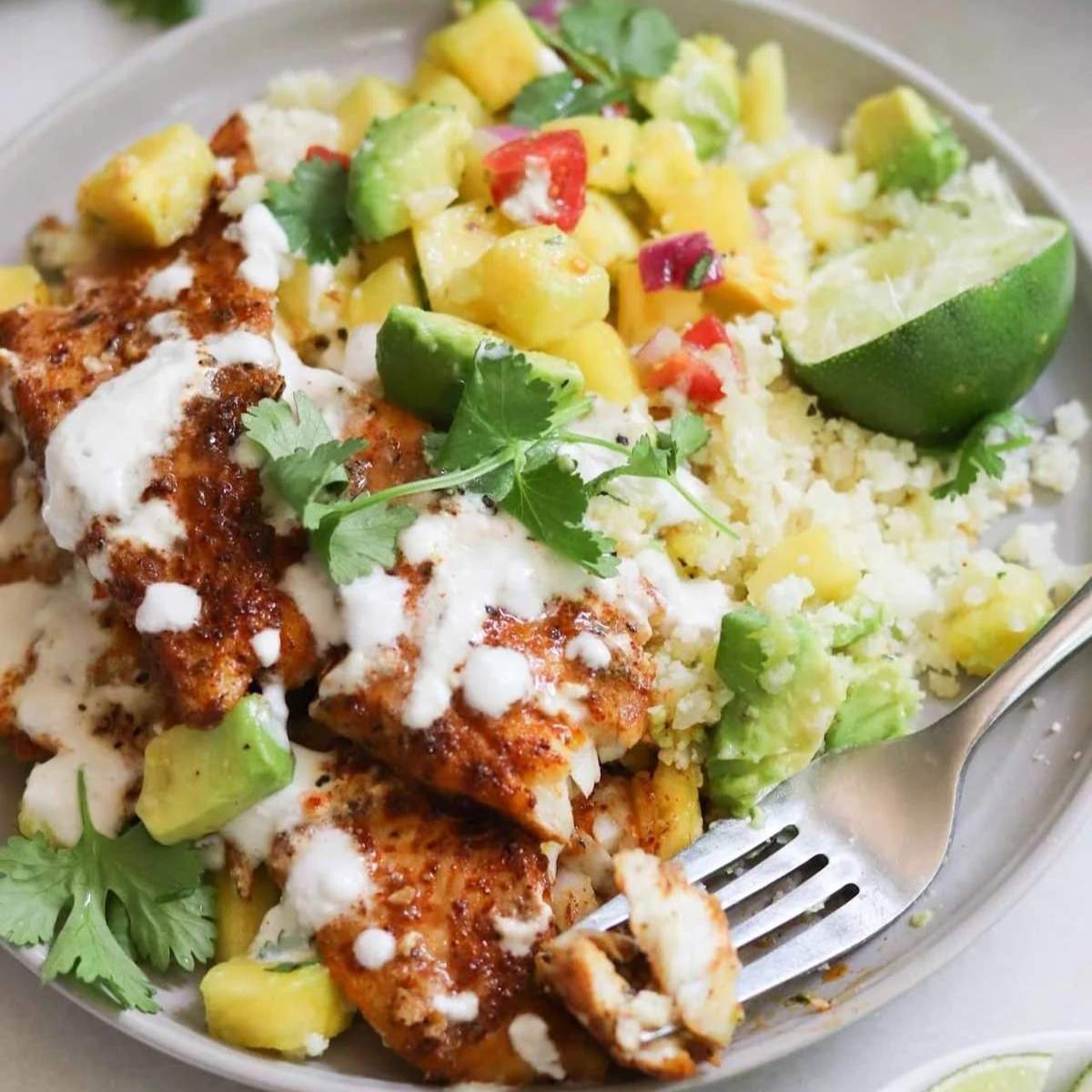 Blackened flounder with pineapple salsa, avocado crema, and cauliflower rice.