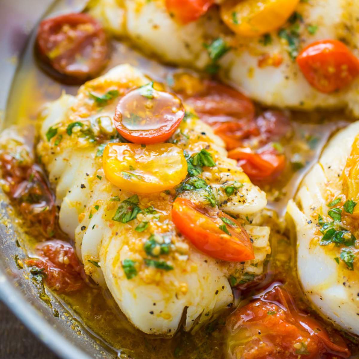 Pan-seared cod with cherry tomatoes, basil, and white wine sauce.