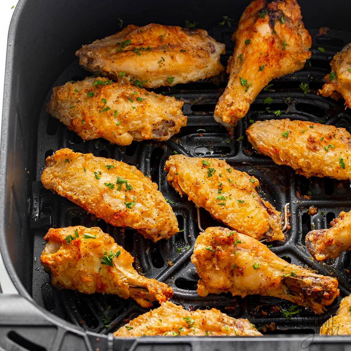 Air fryer chicken wings cooked to crispy perfection, seasoned with herbs and spices, and ready to be served.