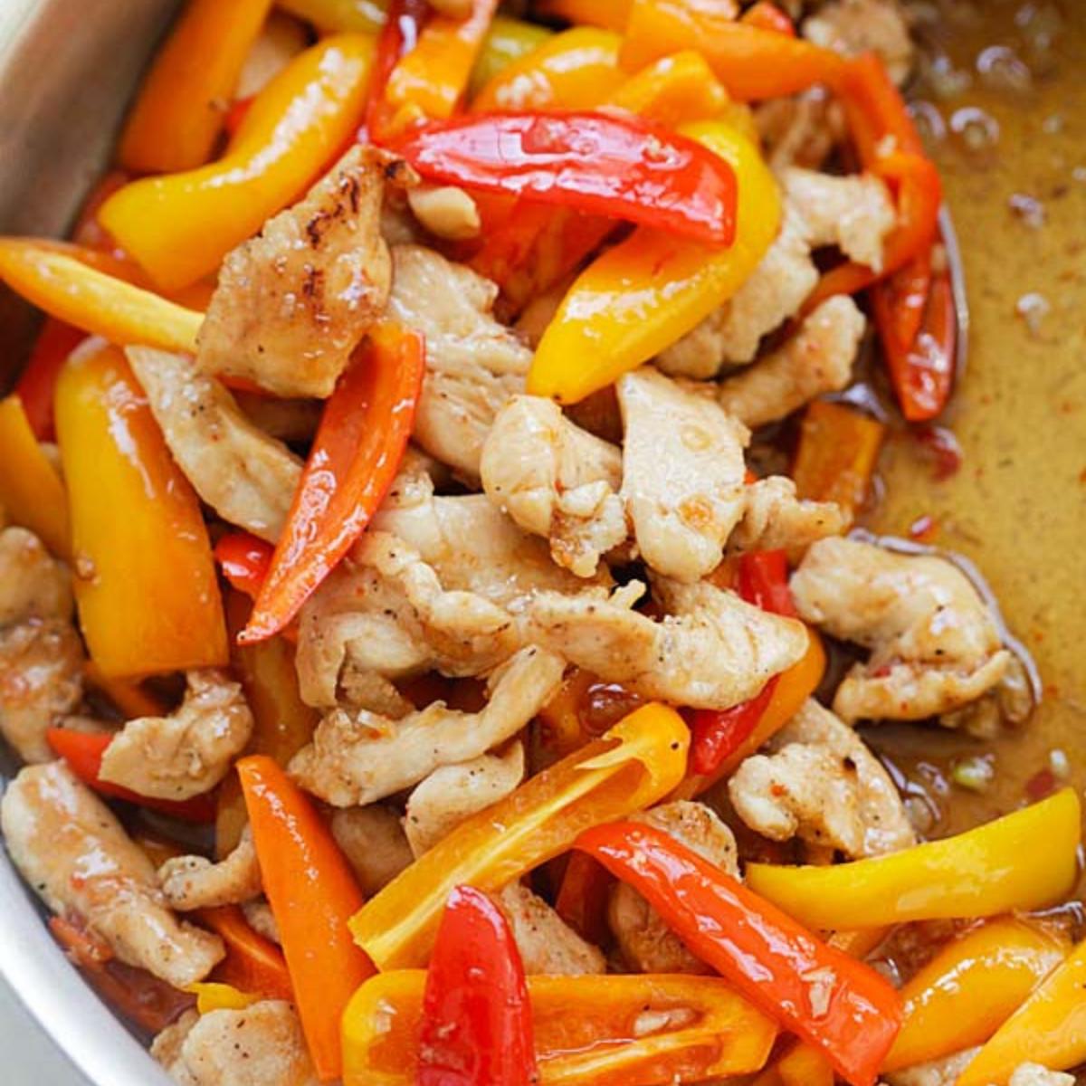 Stir-fry with chicken and colorful mini peppers in a pan.