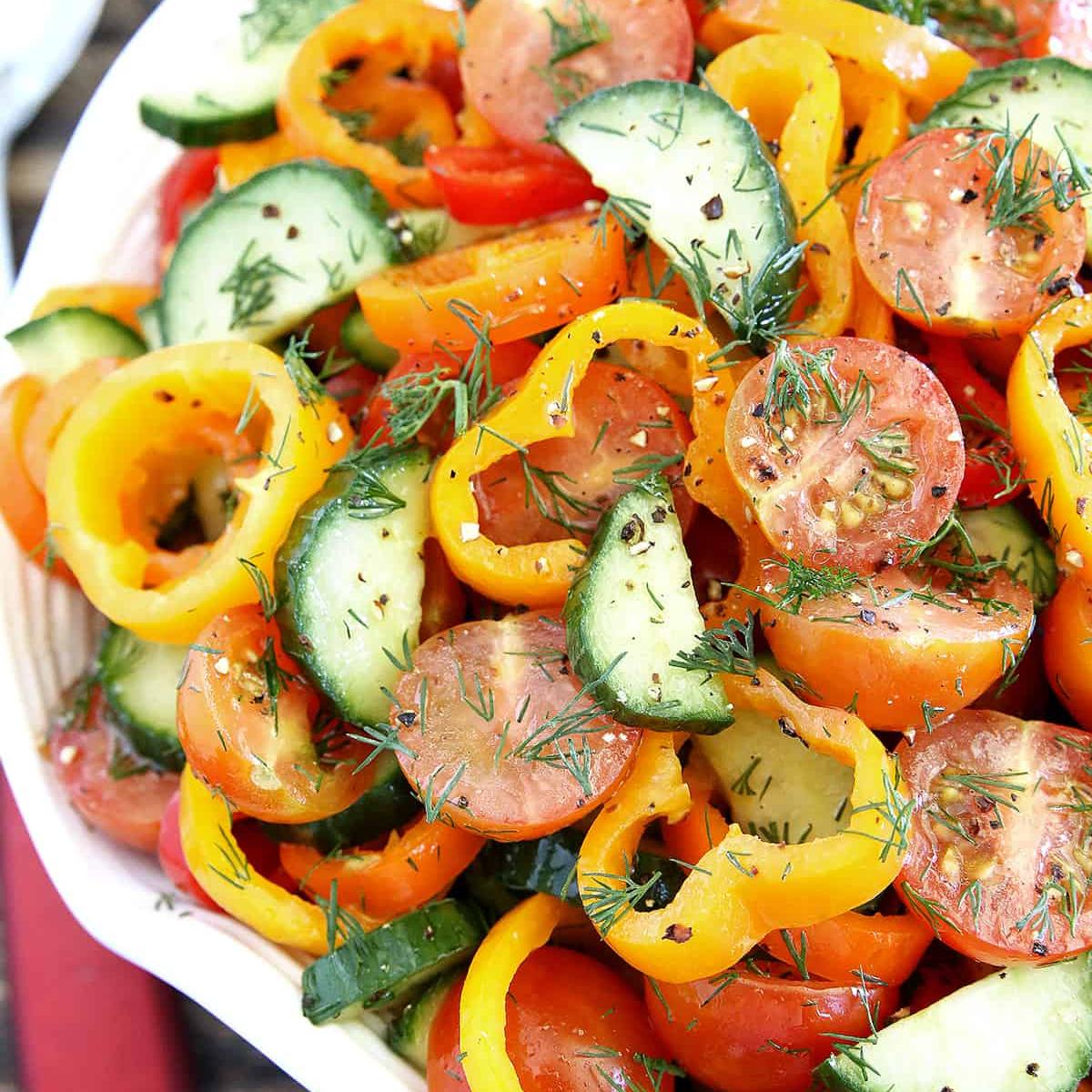  A colorful salad with sliced cucumbers, tomatoes, and bell peppers, tossed with fresh dill and a light dressing.