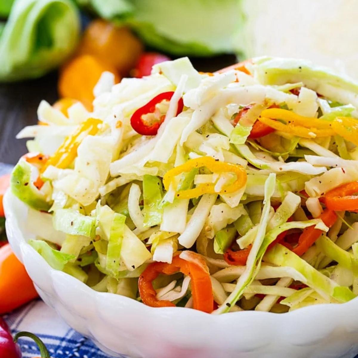 A bowl of coleslaw with shredded cabbage, chopped peppers, and a creamy dressing.