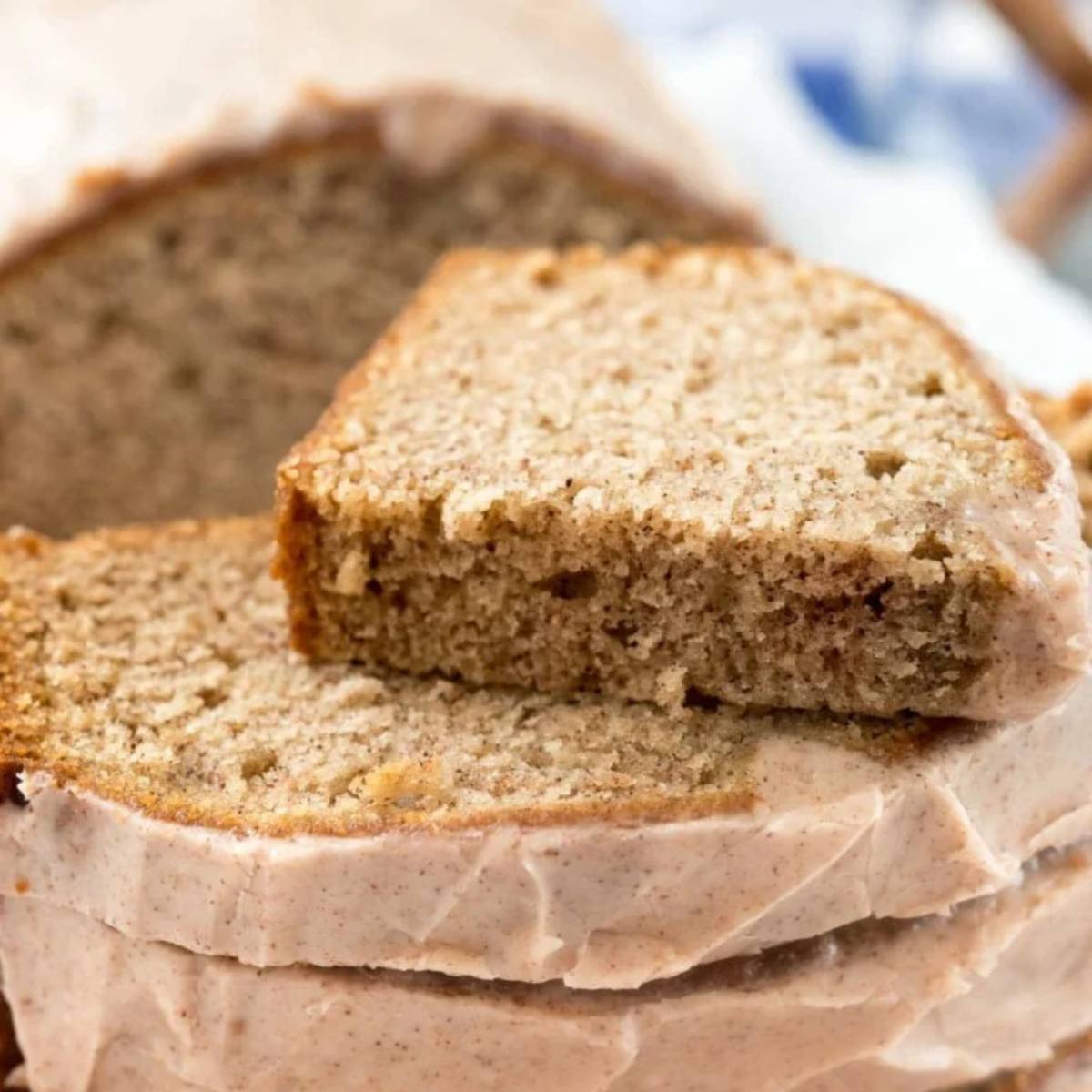 A close-up of slices of pumpkin banana bread, glazed with a pink frosting.