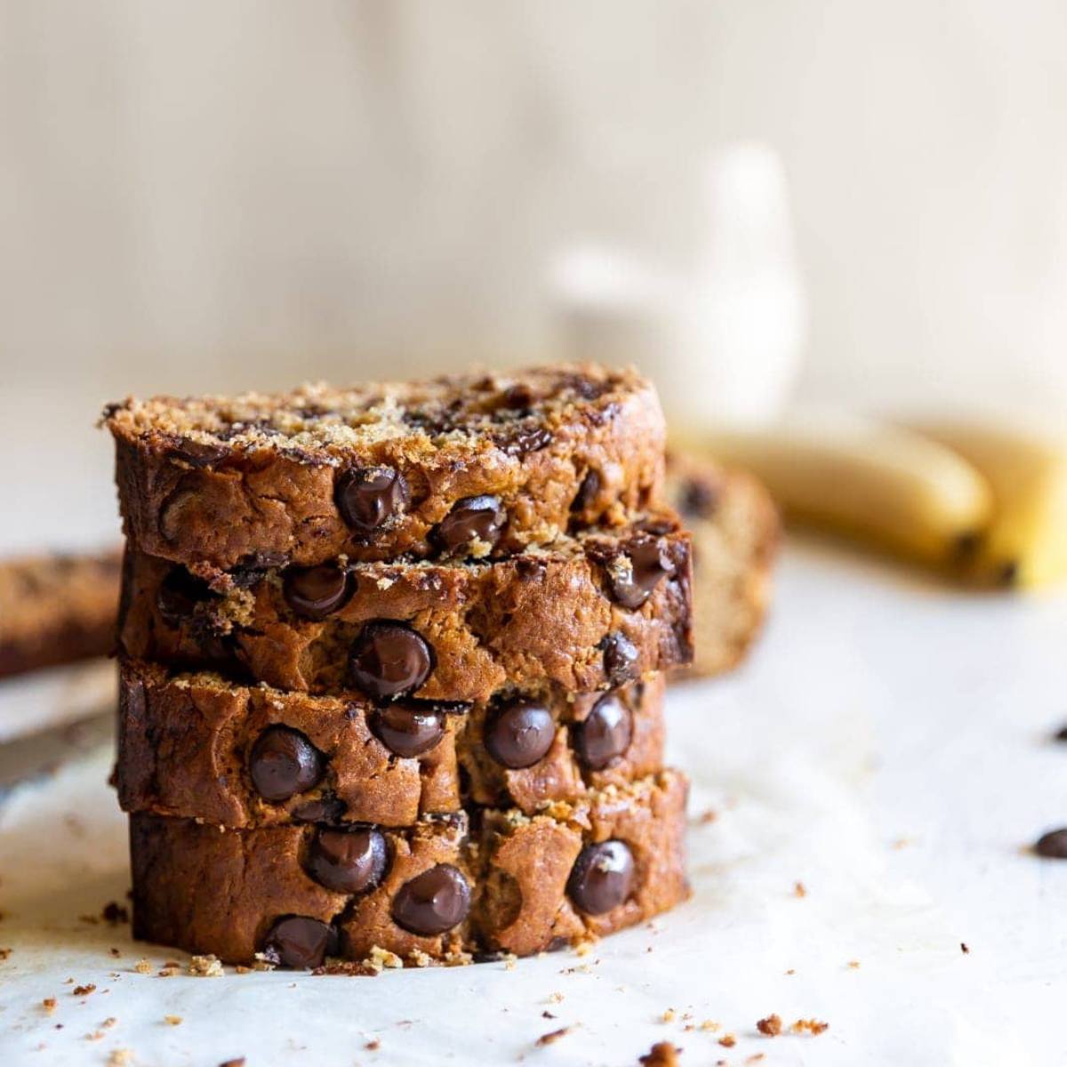 A stack of slices of moist, golden-brown banana bread studded with chocolate chips.