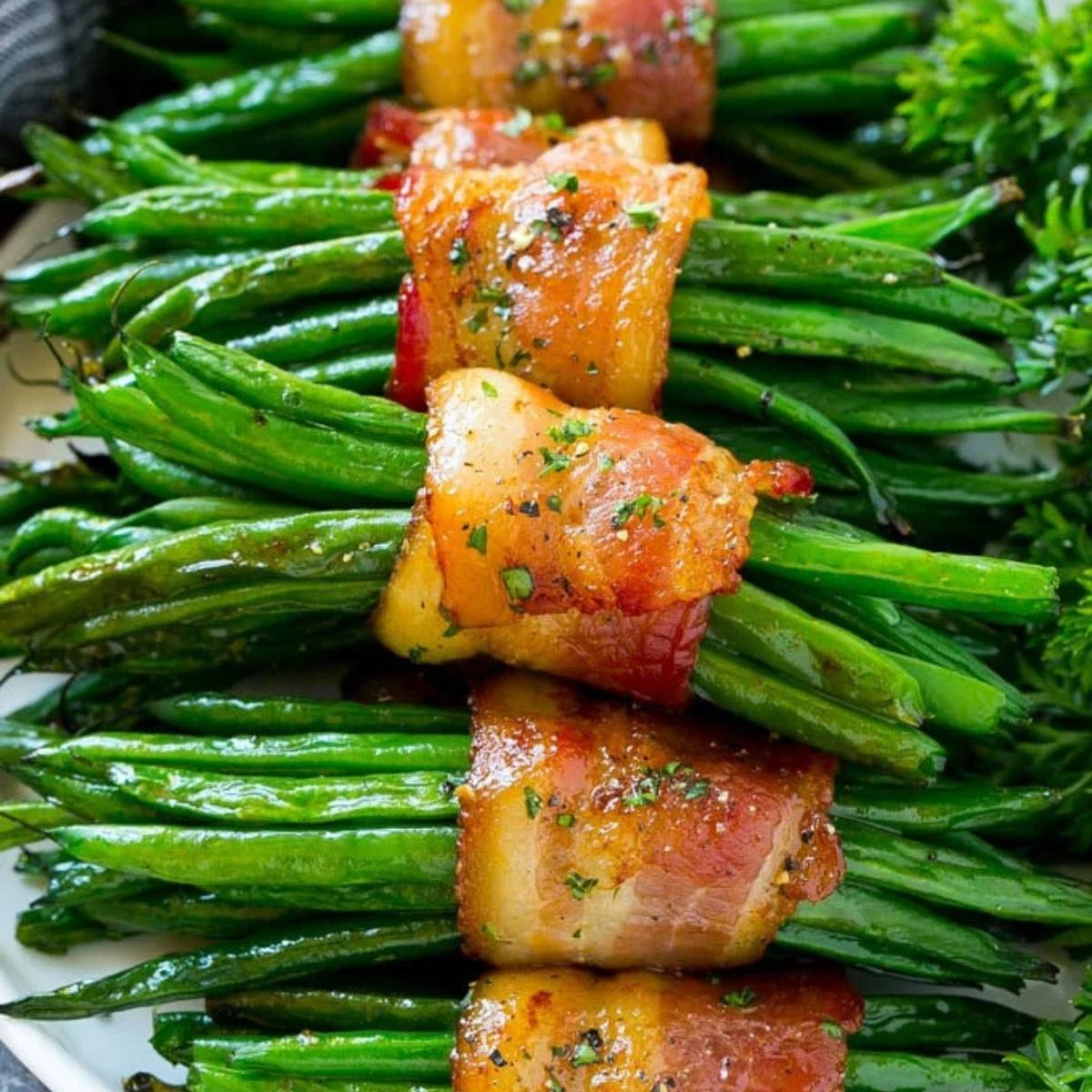 A close-up of crispy bacon-wrapped green beans on a plate.