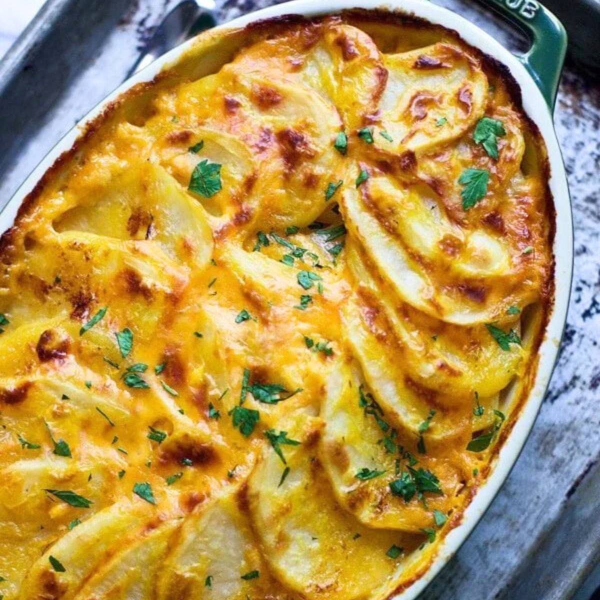 A golden-brown scalloped potato dish with a crispy top and fresh parsley.