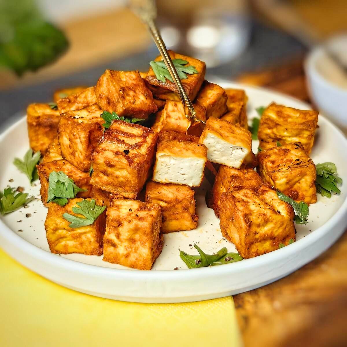 A plate of crispy, golden-brown tofu cubes.