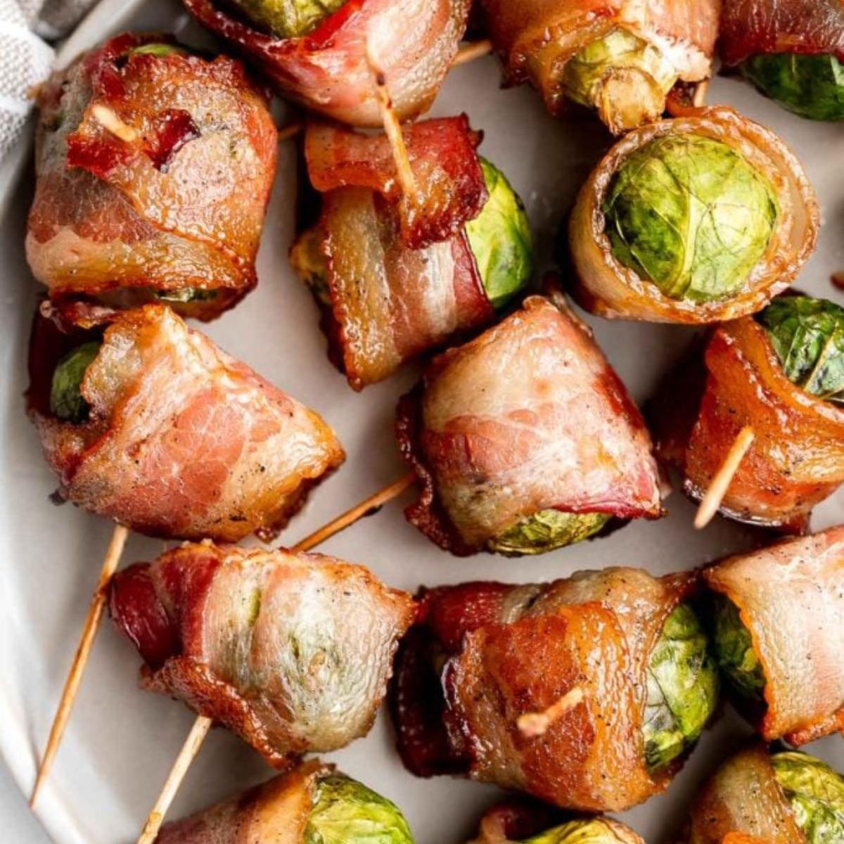 A close-up of bacon-wrapped Brussels sprouts on toothpicks.