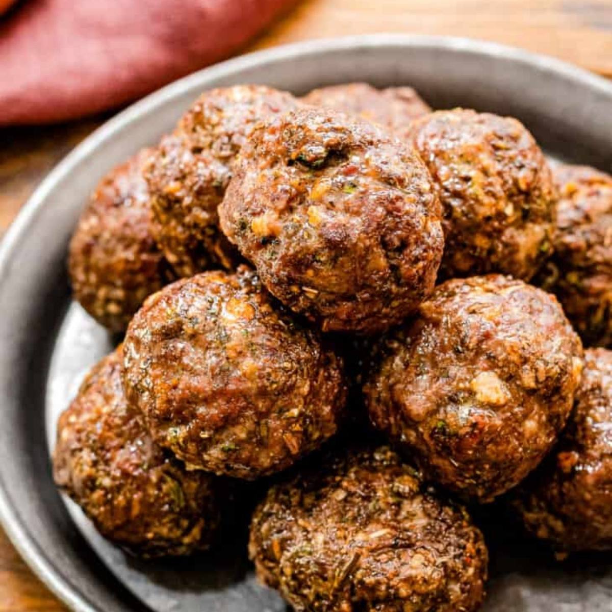 The image shows a pile of meatballs on a plate. They look golden brown and cooked through.