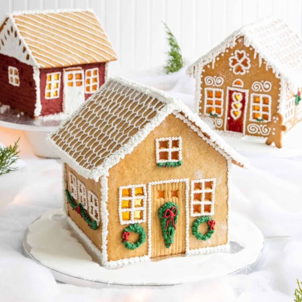 Three elaborately decorated gingerbread houses with different styles and colors.