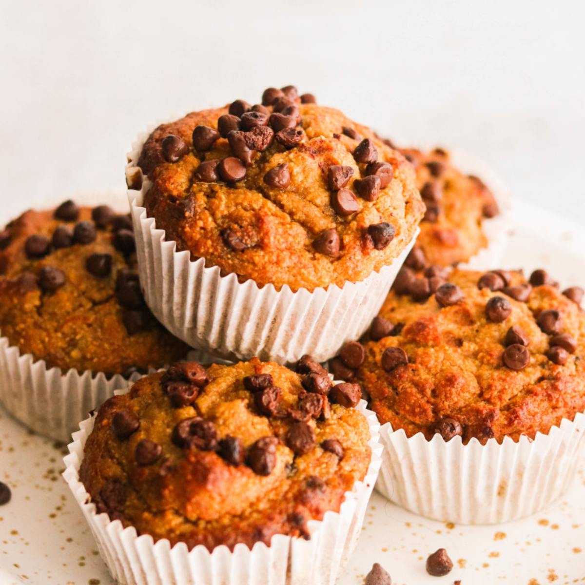 A stack of golden-brown muffins topped with chocolate chips.