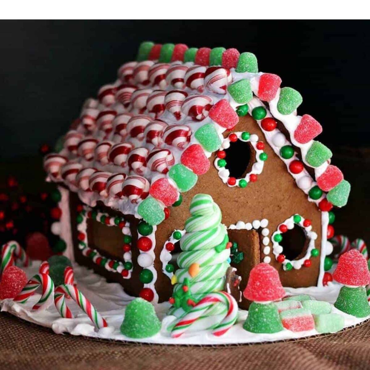 A festive gingerbread house decorated with colorful candies, including gumdrops and candy canes.