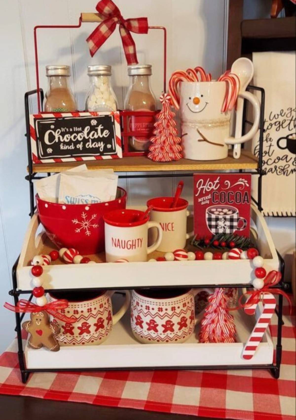 A festive hot cocoa bar with mugs, jars of cocoa mix, marshmallows, and candy canes.