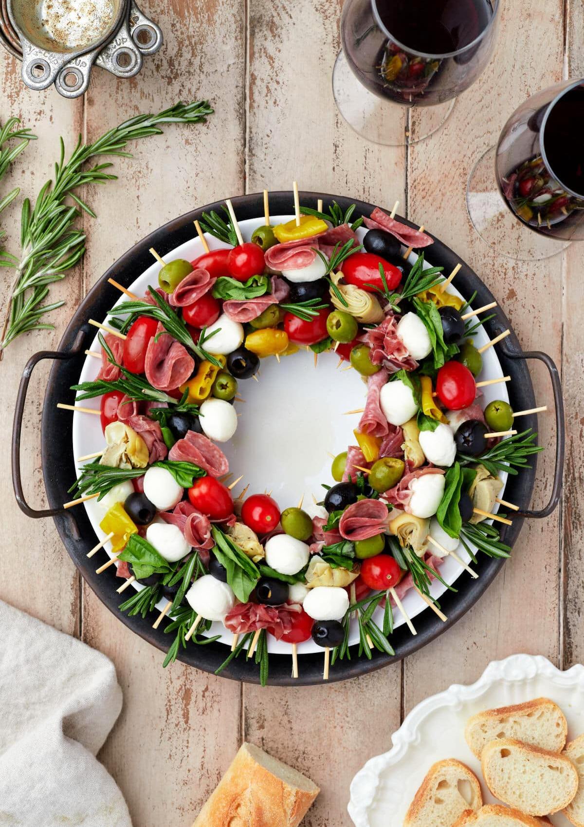 Skewered Mediterranean Charcuterie Wreath featuring an assortment of cold meats, cheese, and various garnishes and more set in a circle to make it visually appealing. 