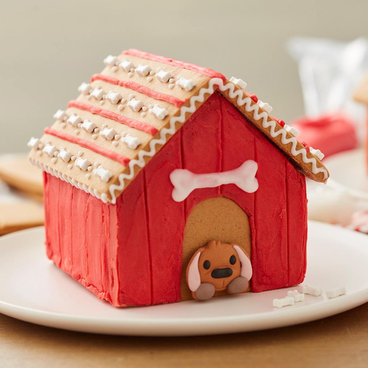 A charming gingerbread dog house decorated with icing and a cute gingerbread puppy peeking out.