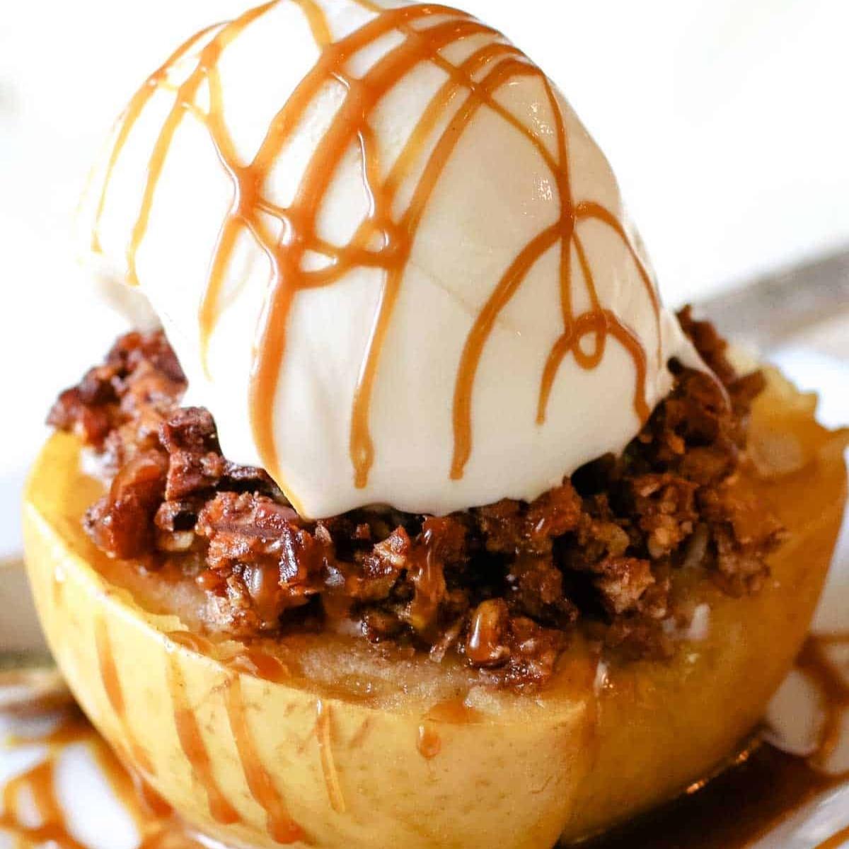 A baked apple topped with a scoop of vanilla ice cream, drizzled with caramel sauce, and sprinkled with a buttery crumble. It looks like a warm and comforting dessert.