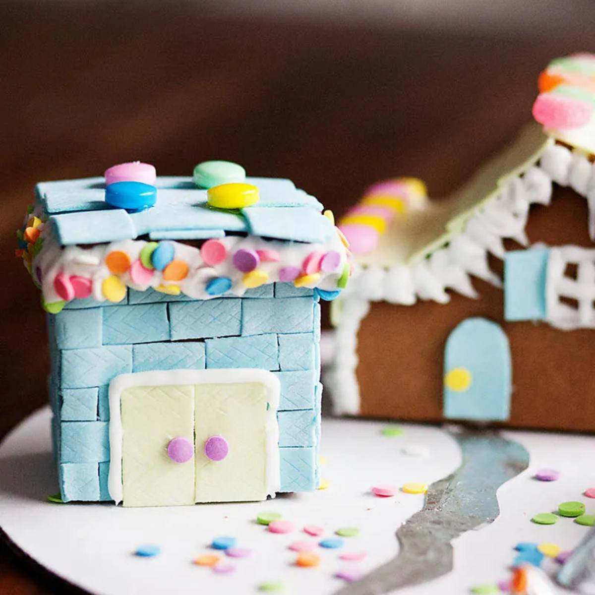 A brightly colored gingerbread house decorated with candies and sprinkles.